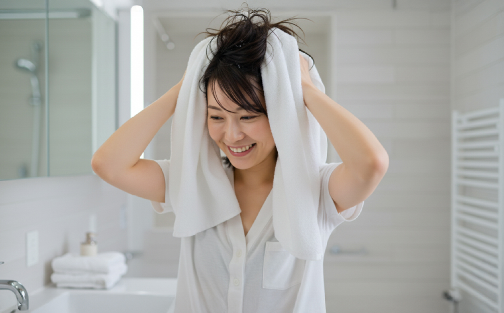 タオルで頭皮を拭く女性